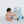 A baby in a blue Seaworld Wooden Baby Walker enjoys pushing and pulling its safely crafted structure, which includes various activity elements on a white background, all designed to support the baby's development.